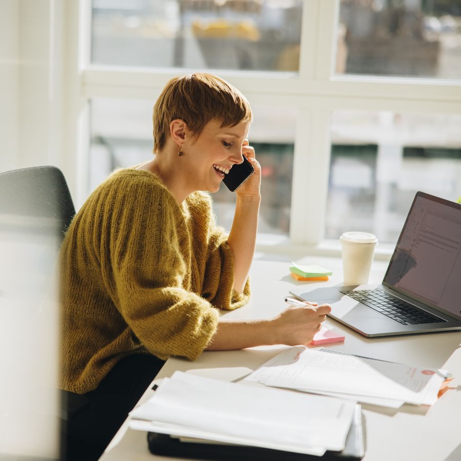 Kvinne sitter og jobber på kontoret sitt